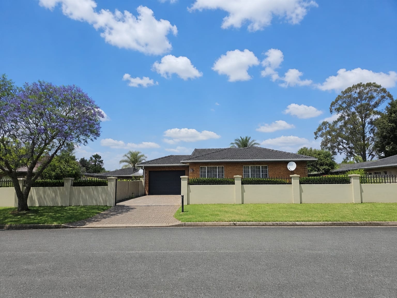 Satellite dish wall-mounted on a face-brick suburban home in Kempton Park